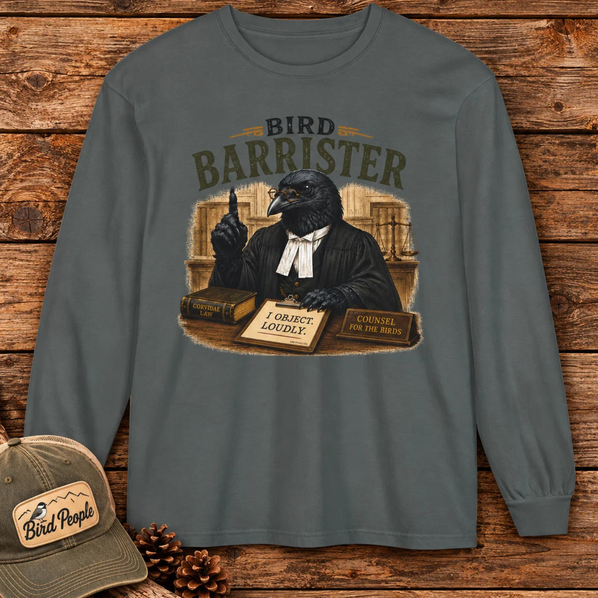 Bird Barrister crow long sleeve t-shirt in Pepper, flat lay on a rustic wood plank background — funny lawyer crow design for birdwatchers and bird lovers.