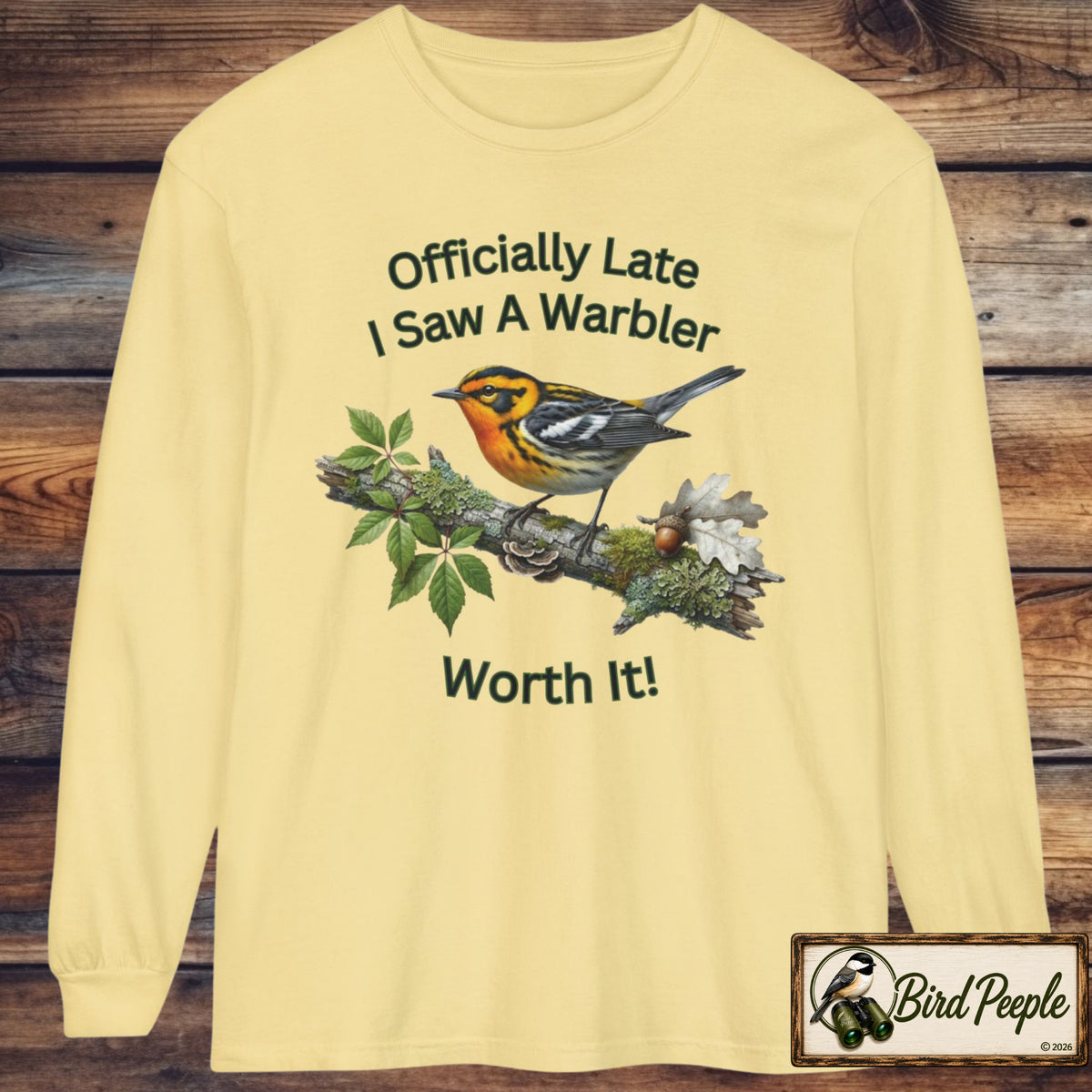 A butter yellow long-sleeve t-shirt with a graphic of a warbler on a branch and the text 'Officially Late I Saw A Warbler Worth It!' displayed on a rustic wooden background. A 'Bird Peeple' brand logo is visible in the bottom right corner. Blackburnian Warbler